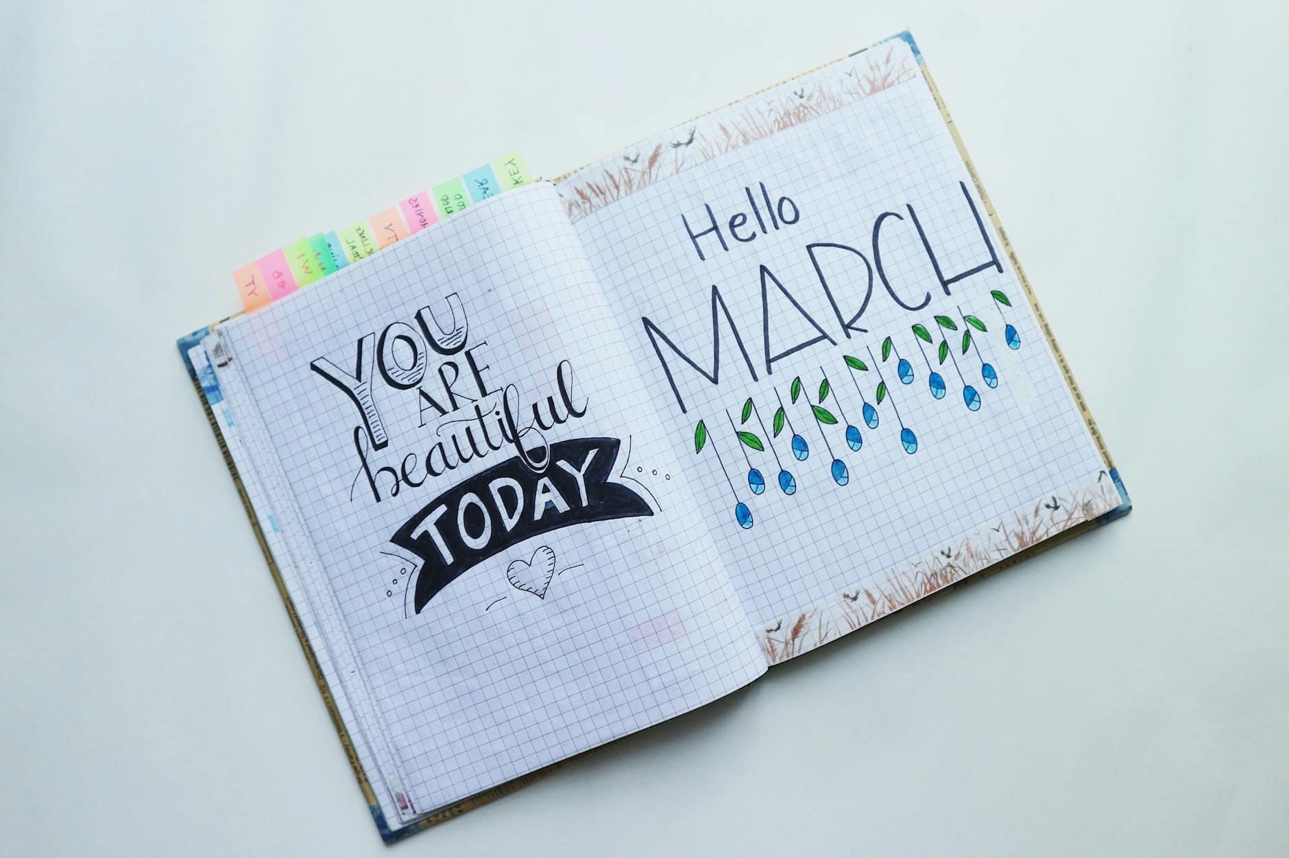 Otwarty bullet journal ze stroną Hello March i cytatem motywacyjnym