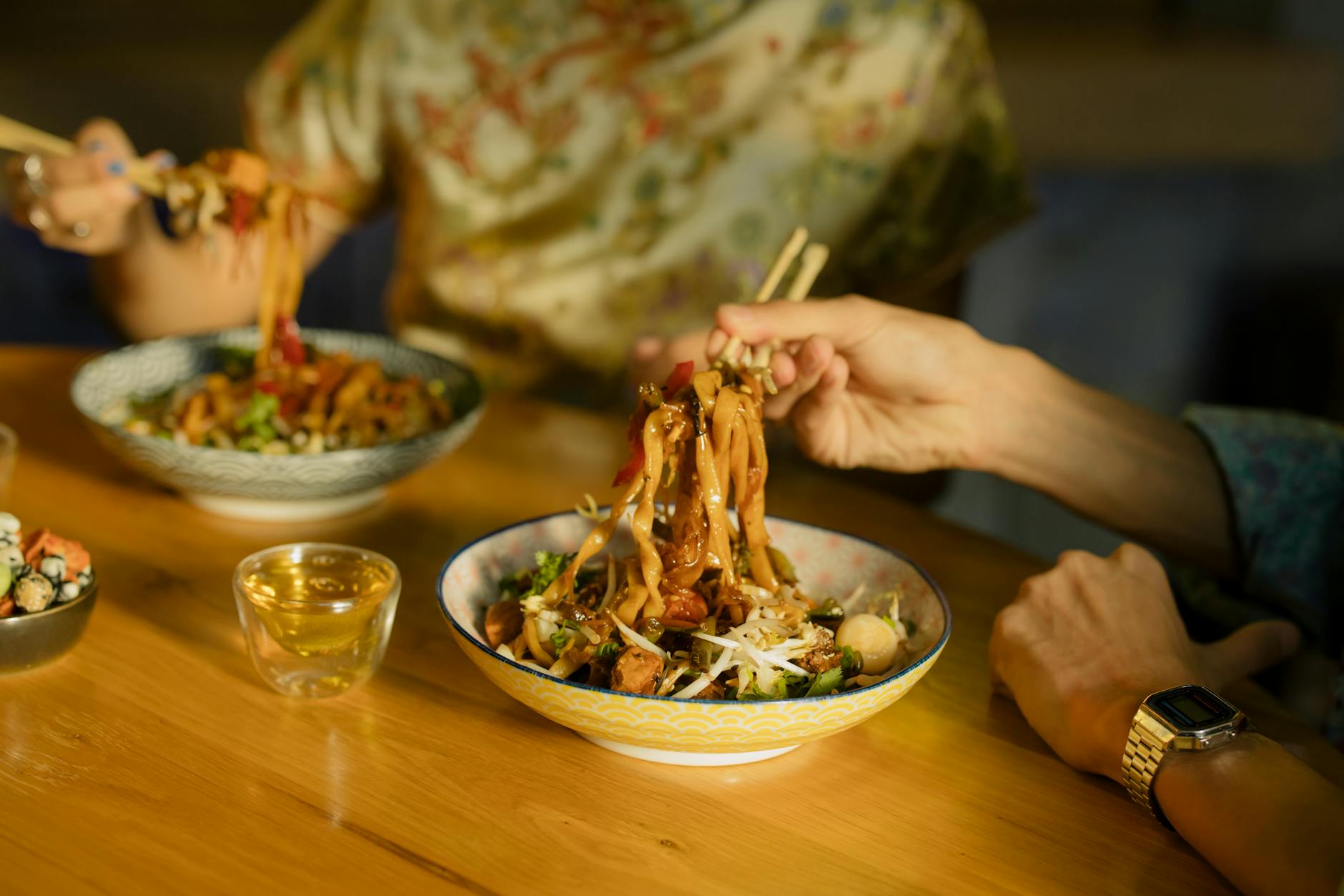 Pałeczki unoszą makaron w azjatyckiej restauracji