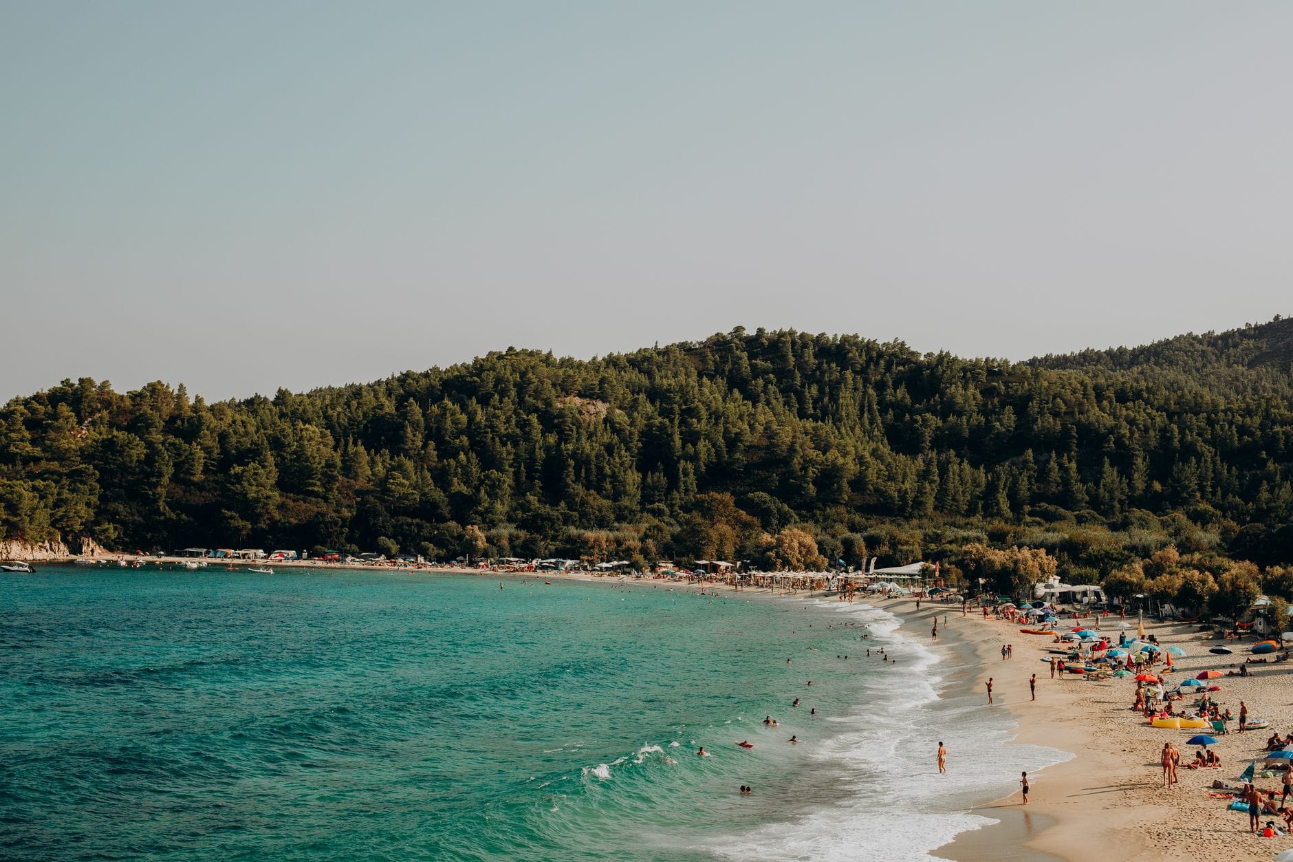 Rodziny wypoczywające na słonecznej, piaszczystej plaży w Grecji